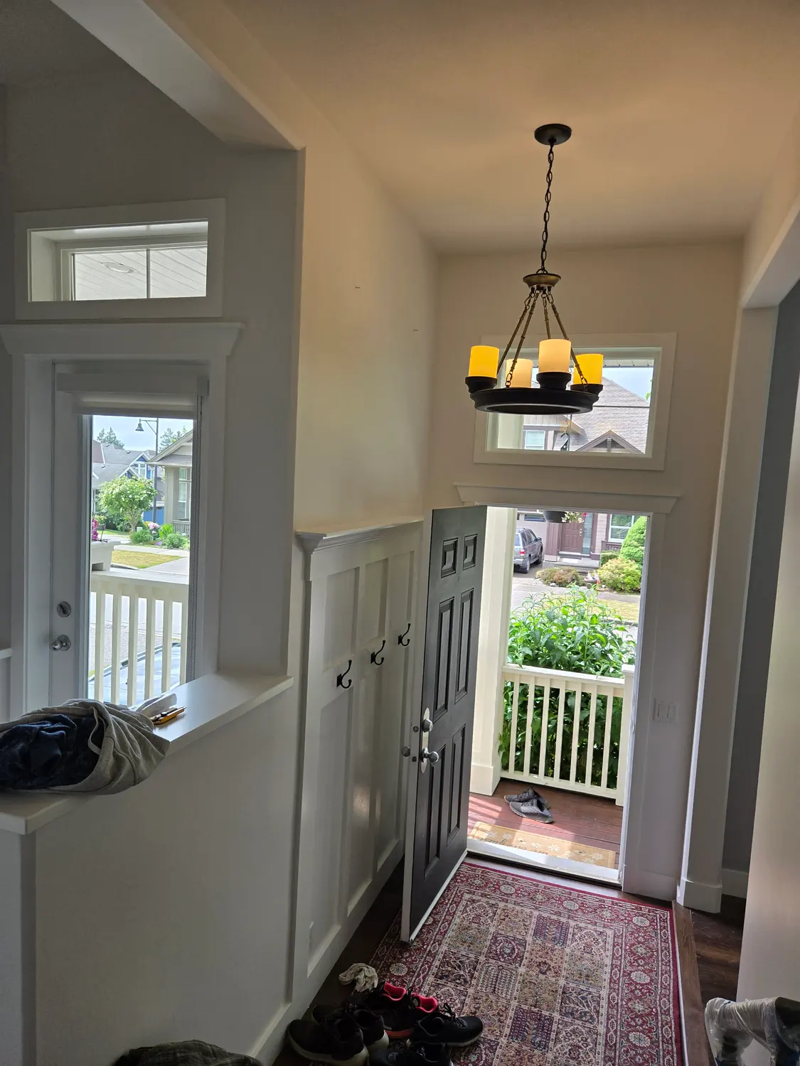 Entryway with fresh white trim, wainscoting and a painted front door