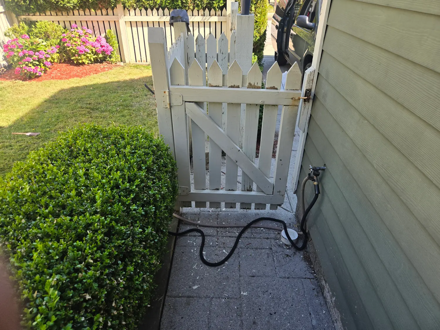 Weathered garden gate with peeling, dirty paint before repainting