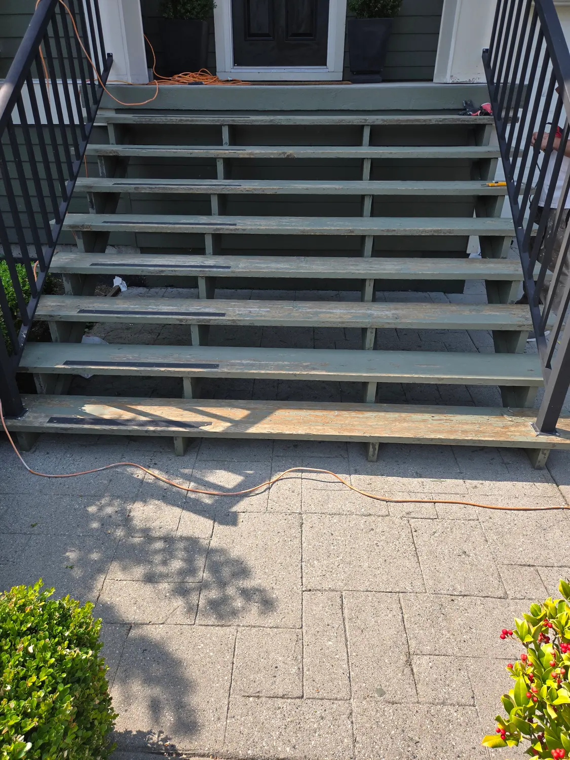 Front steps with worn, flaking green paint before refinishing