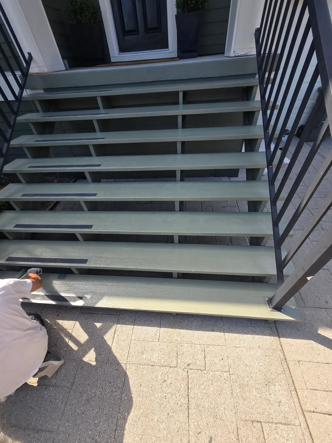 Painter applying a fresh coat to exterior stairs