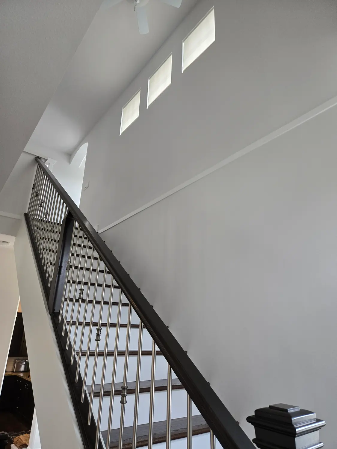 Interior stairwell painted in clean white with a black railing